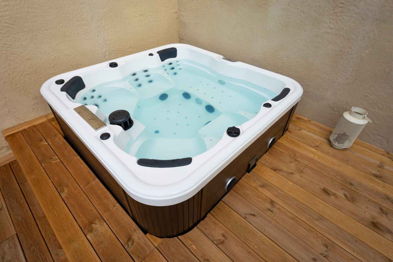 Outdoor terrace jacuzzi with modern white tub, metal handrail, and city skyline view in the background.