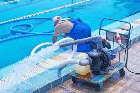 Technician performing swimming pool equipment refurbishment services to restore pool system performance